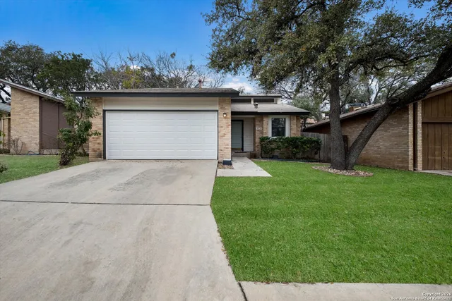 front view of a house with a yard and potted plants