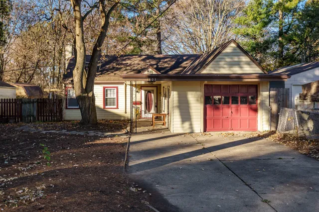 a view of a house with large windows and a large tree
