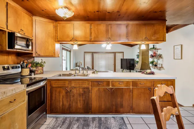 a kitchen with a sink a stove and cabinets