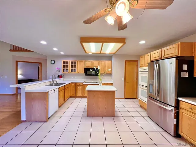a kitchen with stainless steel appliances granite countertop a refrigerator and a stove top oven