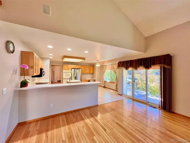 a living room with stainless steel appliances with wooden floor