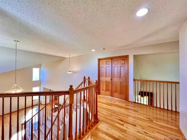 a view of a hallway with wooden floor and windows