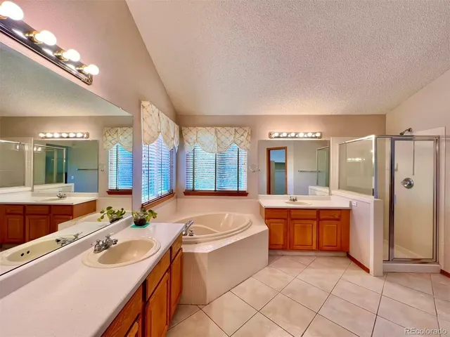 a large spacious bathroom with a granite countertop tub sink shower and mirror