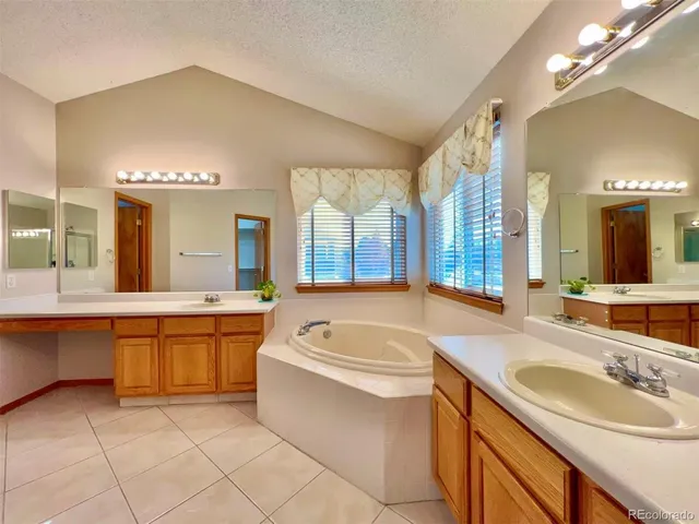 a bathroom with a granite countertop sink and a bathtub