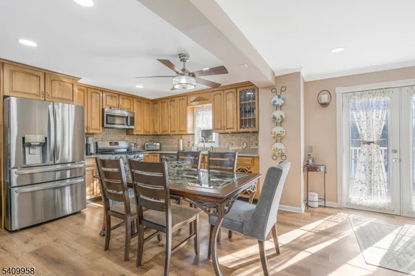 a dining room with stainless steel appliances a table and chairs