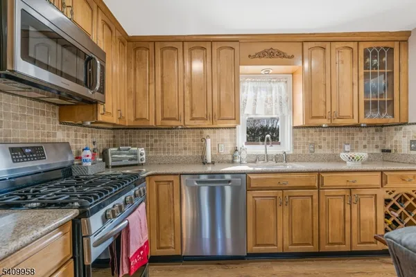 a kitchen with granite countertop wooden cabinets and a stove top oven