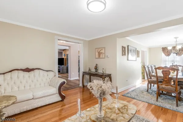 a living room with furniture and a dining table with wooden floor