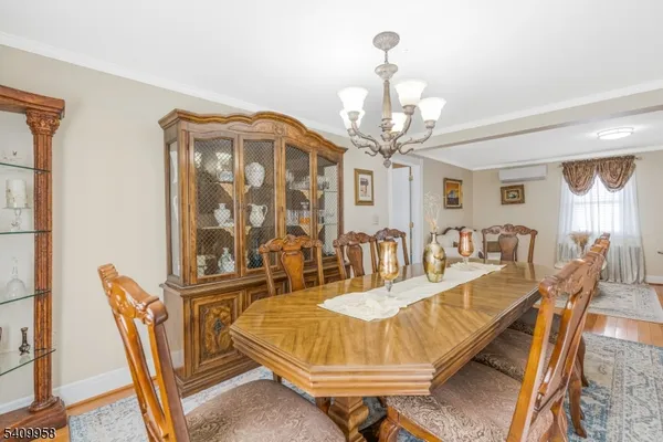 a dining room with furniture a chandelier and wooden floor
