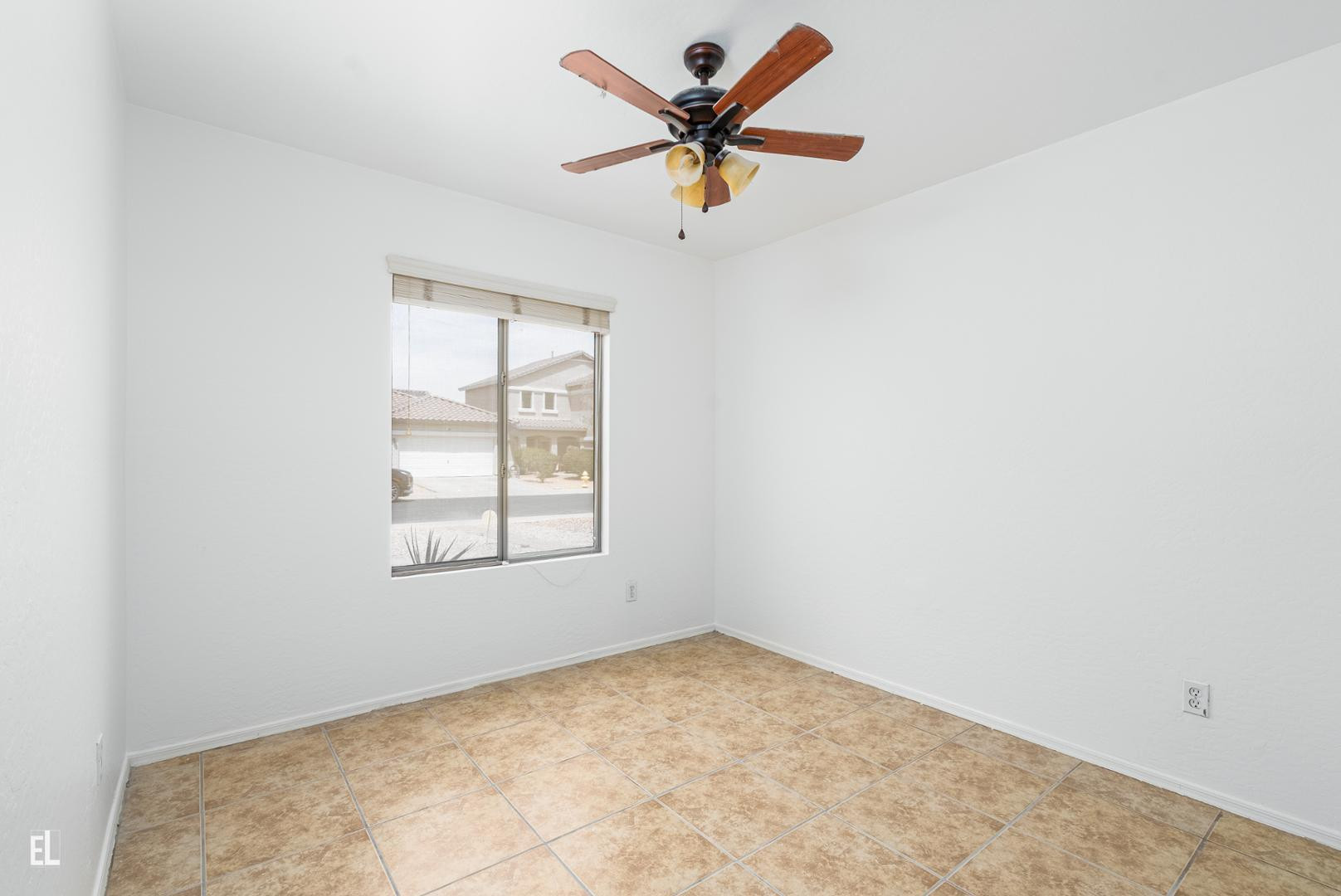12937 West Bloomfield Road El Mirage, AZ 85335 - Photo 12 of 25 an empty room with a window and a fan