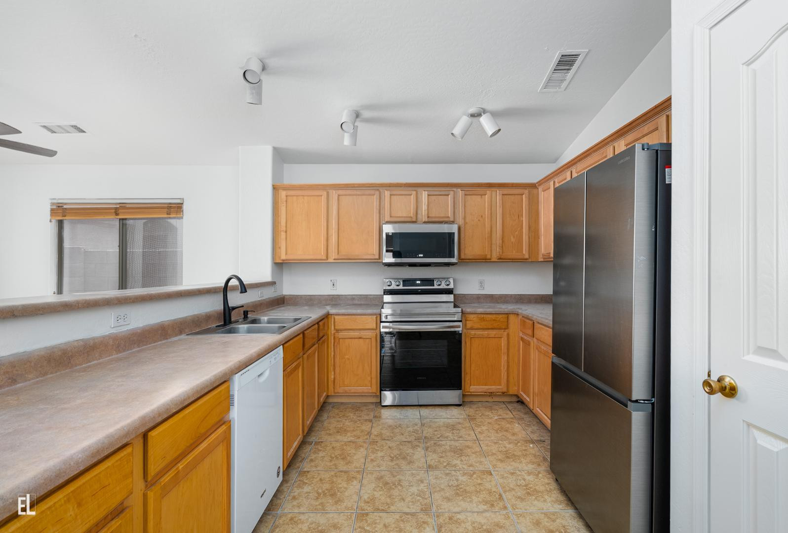 12937 West Bloomfield Road El Mirage, AZ 85335 - Photo 15 of 25 a kitchen with stainless steel appliances granite countertop a sink stove and refrigerator