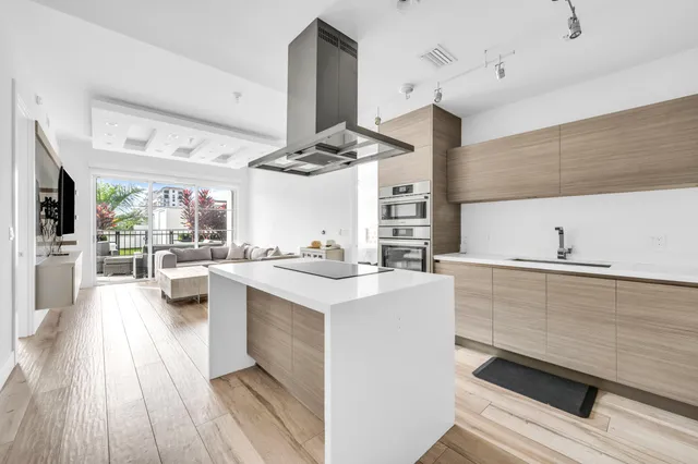 a kitchen with stainless steel appliances a stove a sink dishwasher and white cabinets with wooden floor