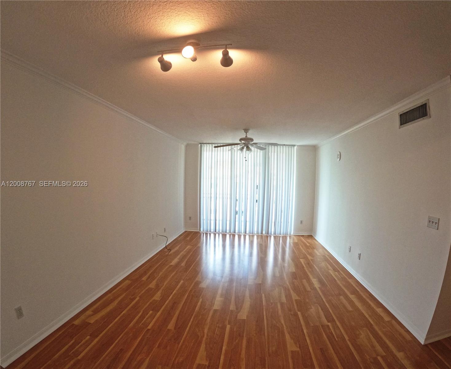 2665 Southwest 37th Avenue, Unit 710 Miami, FL 33133 - Photo 3 of 13 a view of an empty room with wooden floor and a window