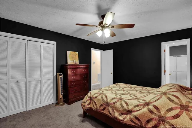 a bedroom with a bed and a ceiling fan