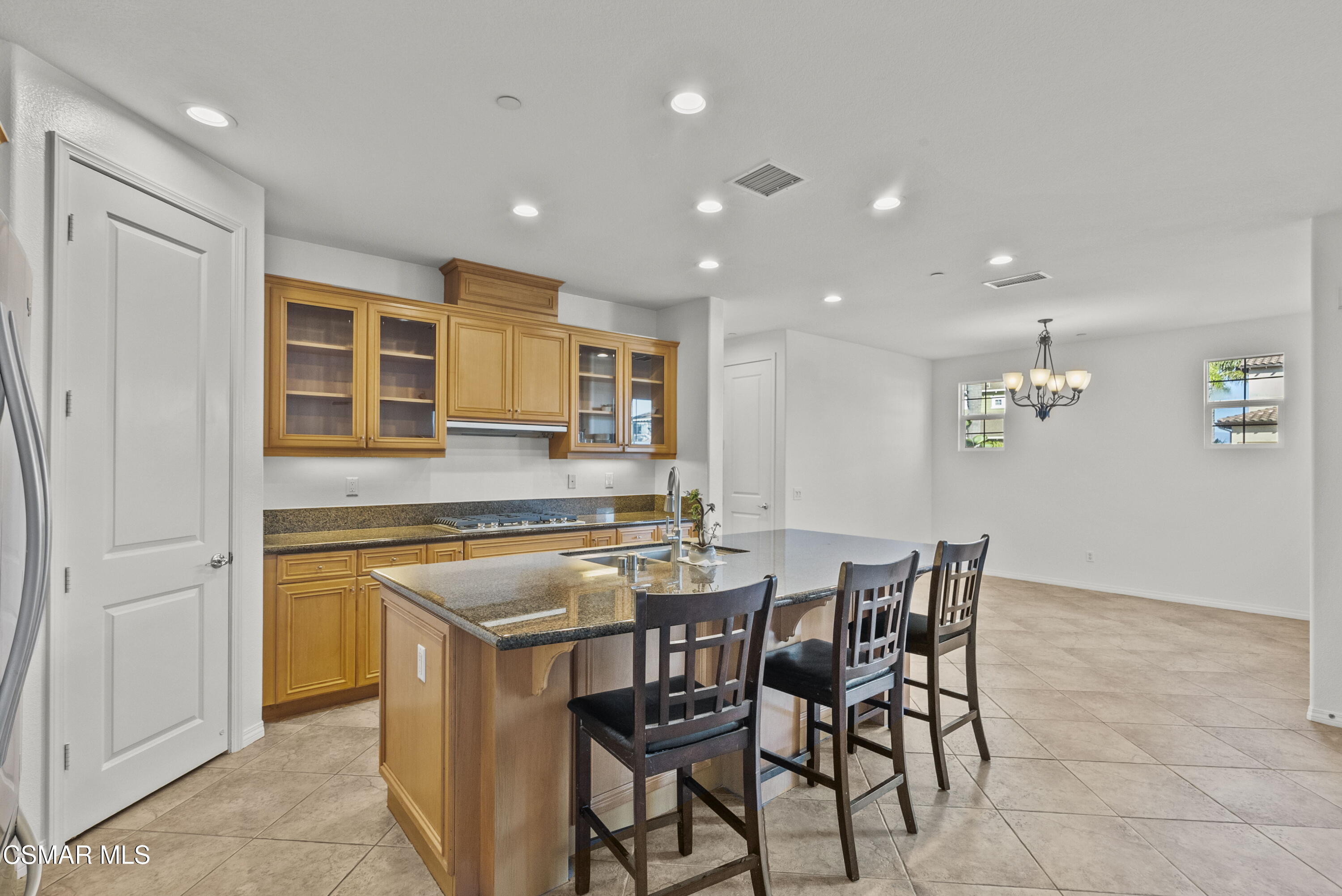 1316 Estuary Way Oxnard, CA 93035 - Photo 18 of 46 a kitchen with a dining table chairs and cabinets