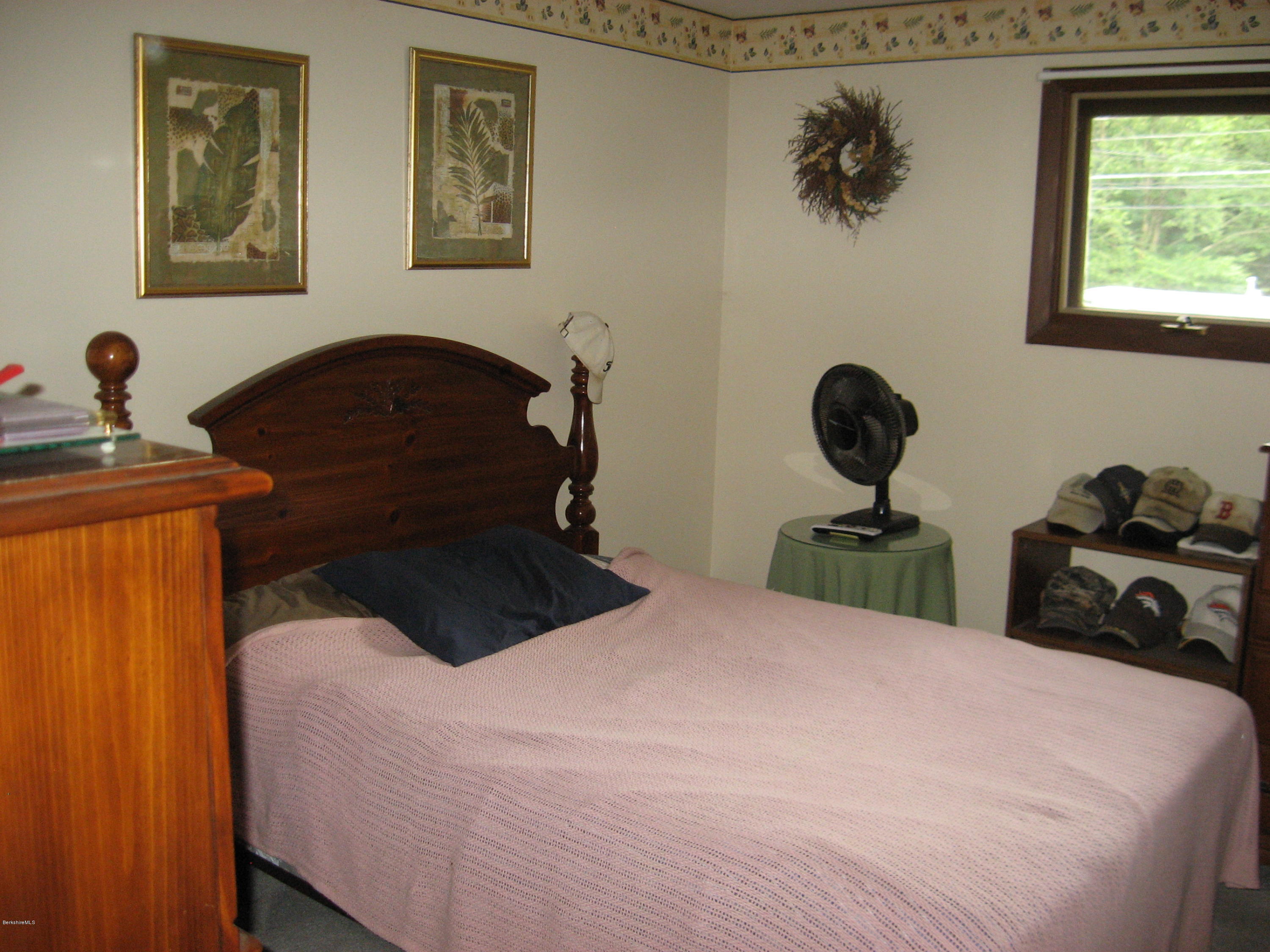 800 Sandmill Road Cheshire, MA 01225 - Photo 22 of 41 a bedroom with a bed and a chandelier