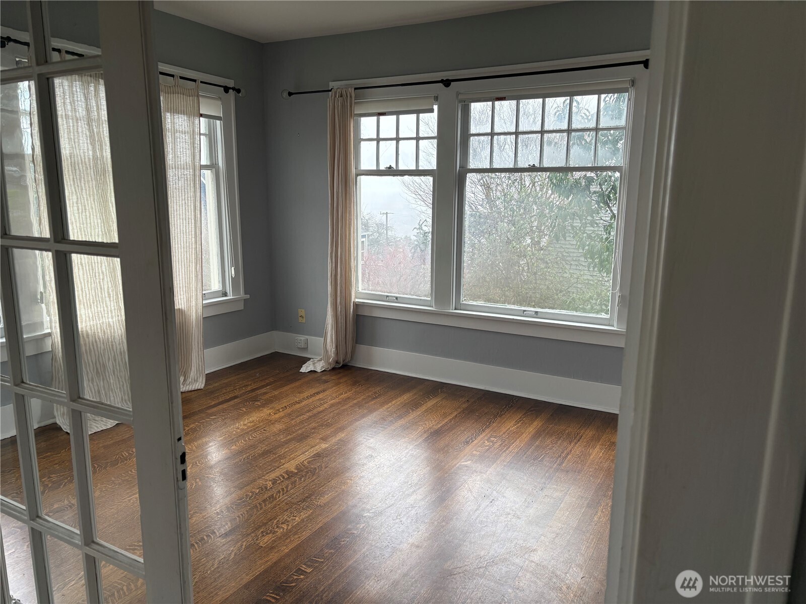 3201 South Charles Street Seattle, WA 98144 - Photo 6 of 25 an empty room with wooden floor and windows