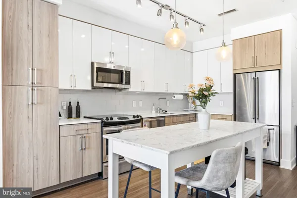 a kitchen with appliances cabinets and wooden floor