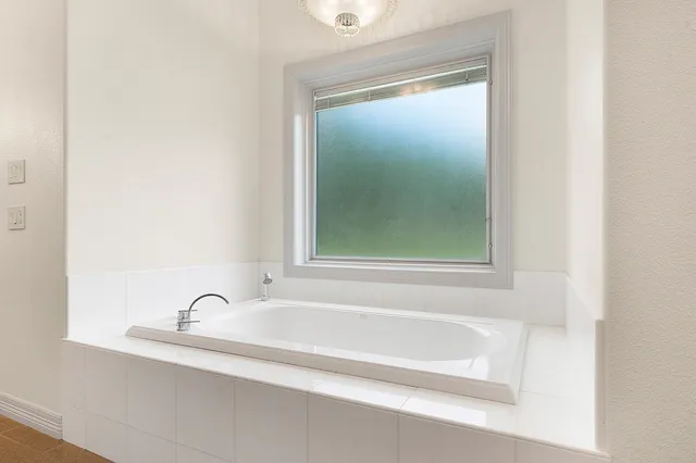 a bathroom with a tub a sink and shower