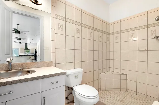 a bathroom with a sink a toilet and shower