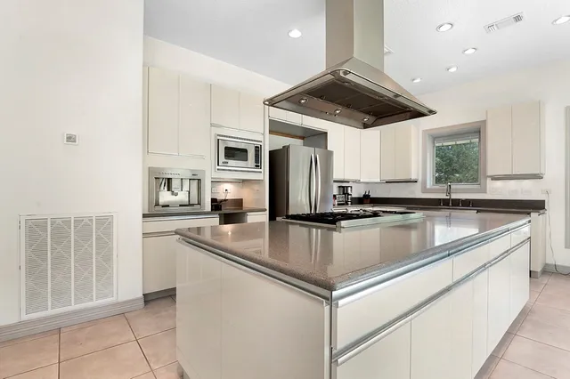 a kitchen with stainless steel appliances granite countertop a sink a stove and a refrigerator