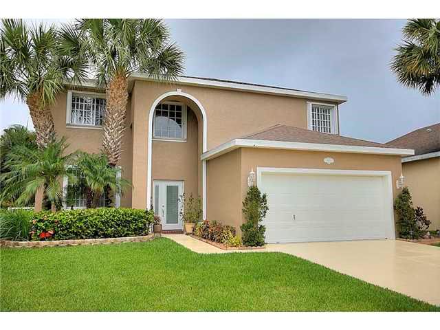 2563 Southeast Springtree Place Stuart, FL 34997 - Photo 1 of 20 a front view of a house with garden