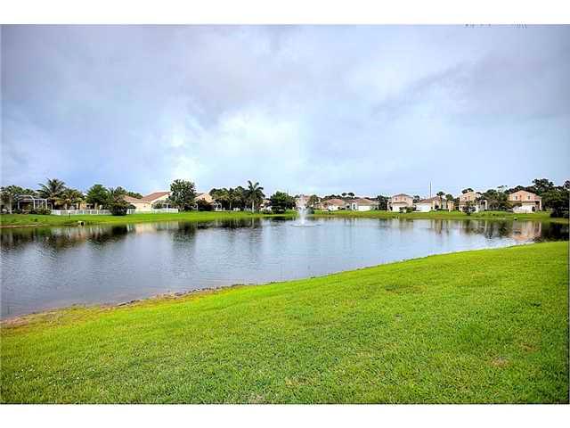 2563 Southeast Springtree Place Stuart, FL 34997 - Photo 20 of 20 a view of a lake with houses in the back