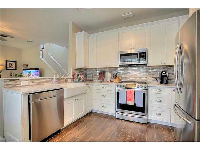 2563 Southeast Springtree Place Stuart, FL 34997 - Photo 7 of 20 a kitchen with kitchen island a sink cabinets and stainless steel appliances