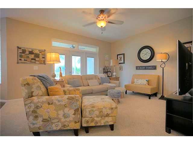 2563 Southeast Springtree Place Stuart, FL 34997 - Photo 9 of 20 a living room with furniture a clock and a flat screen tv