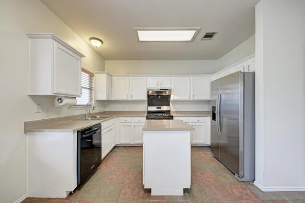 a kitchen with a sink a refrigerator and cabinets