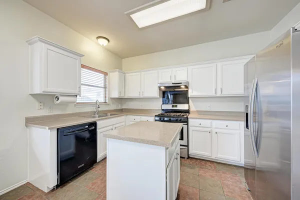 a kitchen with cabinets stainless steel appliances and a window