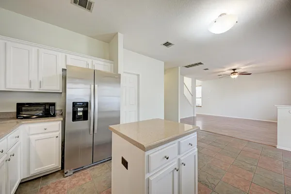 a kitchen with a refrigerator a sink and cabinets