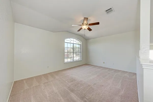 a view of room with a ceiling fan and window