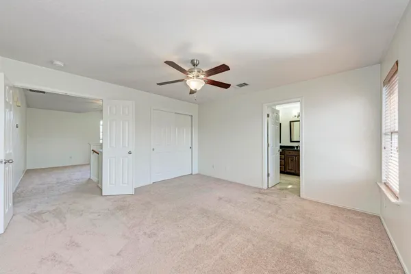 an empty room with closet and windows