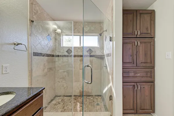 a bathroom with a granite countertop shower mirror and toilet