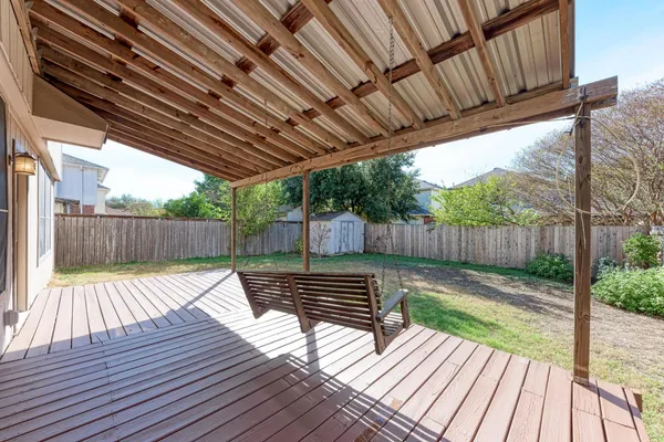 a view of a backyard with large trees and wooden fence