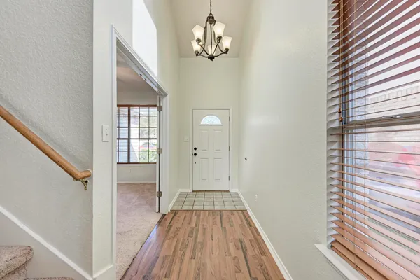 a view of a hallway with wooden floor and staircase