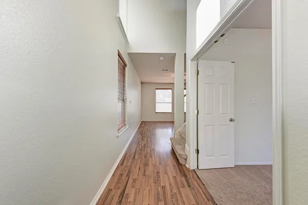a view of a hallway with wooden floor and staircase