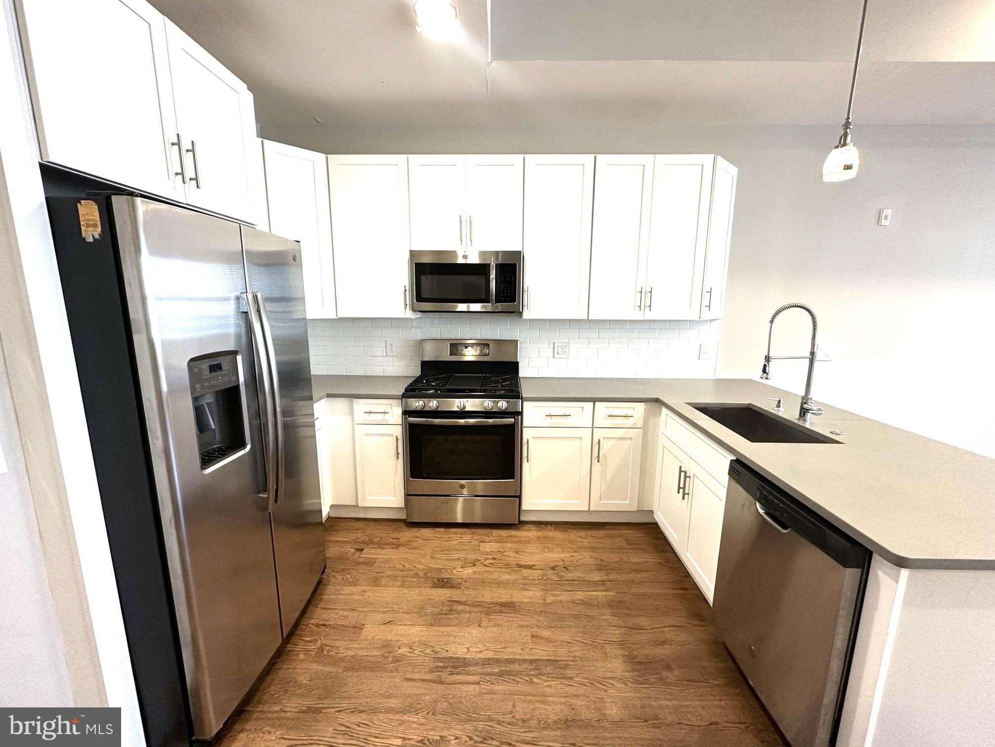 963 Shackamaxon Street, Unit 4 Philadelphia, PA 19125 - Photo 14 of 35 a kitchen with stainless steel appliances a refrigerator sink and microwave