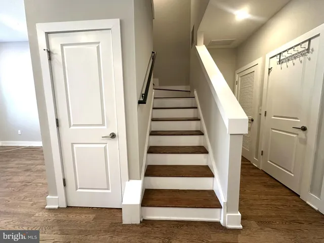 an empty room with wooden floor ceiling fan and windows