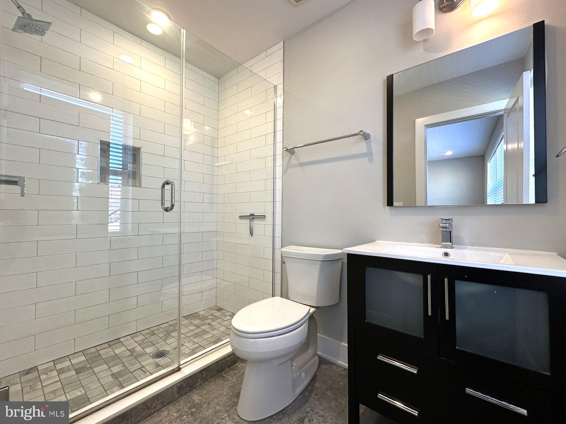 963 Shackamaxon Street, Unit 4 Philadelphia, PA 19125 - Photo 22 of 35 a bathroom with a toilet sink a mirror and shower