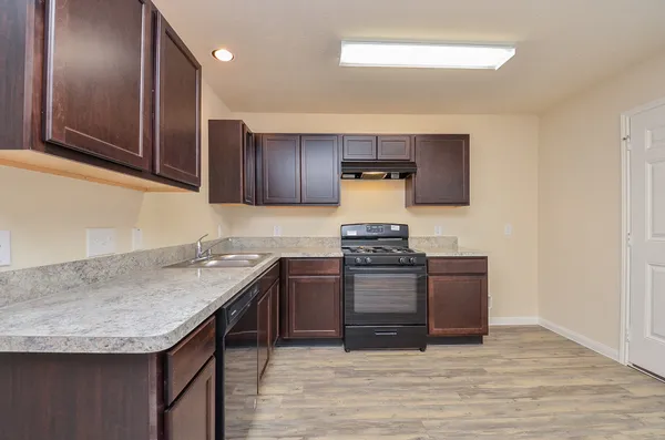 a kitchen with granite countertop a sink and a stove top oven