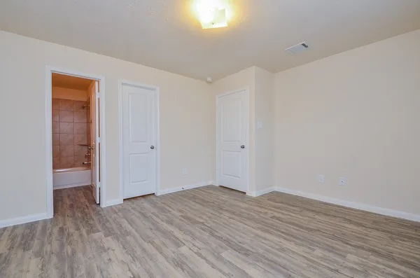 a view of empty room with wooden floor