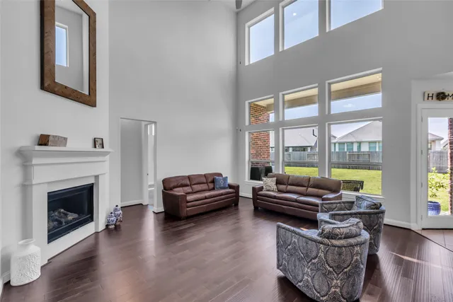 a living room with furniture a fireplace and a floor to ceiling window