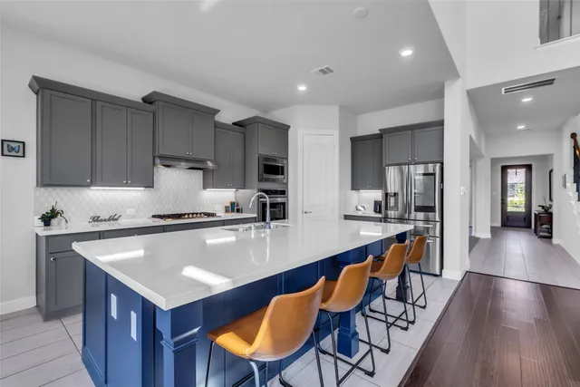 a large kitchen with lots of counter space and stainless steel appliances