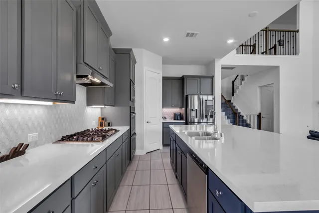 a kitchen with kitchen island stainless steel appliances a sink stove and cabinets