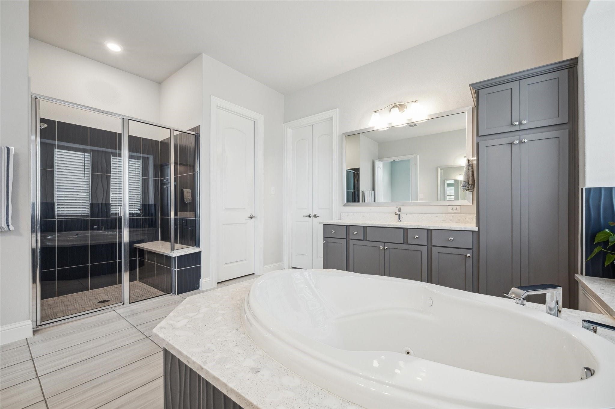 423 Round Top Street Webster, TX 77598 - Photo 25 of 49 a bathroom with a granite countertop tub sink shower and mirror