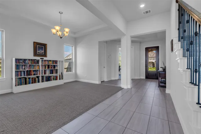 en view of an empty room with a window and wooden floor