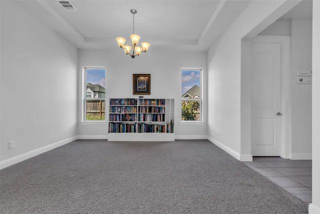 a view of an empty room with a window and fireplace