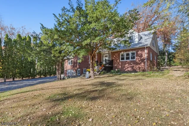 a front view of a house with a yard and trees