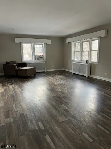 a view of a room with wooden floor and windows
